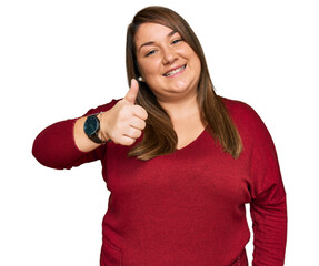Beautiful brunette plus size woman wearing casual clothes doing happy thumbs up gesture with hand....