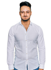 Young arab man wearing casual clothes puffing cheeks with funny face. mouth inflated with air, crazy expression. - obrazy, fototapety, plakaty