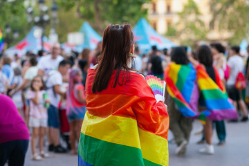 Diverse people at pride parade walking with rainbow flags, celebrating LGBTQ rights