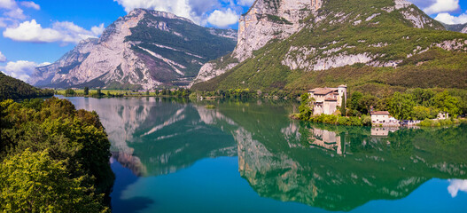 Beautiful Toblino lake is considered one of the most romantic lakes in the Trentino, Italy. aerial drone panoramic view with medieval castle. Sarca Valley