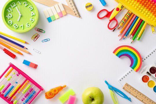 Step into enchanting realm of early education with this top-down photograph: delightful display of colorful child stationery against white background, empty round frame for text or advert placement