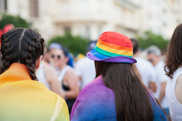Young woman wearing a rainbow bucket hat at pride parade event in Valencia, Spain