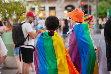 Diverse people at pride parade walking with rainbow flags, celebrating LGBTQ rights