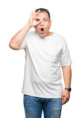 Fototapeta premium Middle age arab man wearig white t-shirt over isolated background doing ok gesture shocked with surprised face, eye looking through fingers. Unbelieving expression.