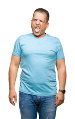 Fototapeta premium Middle age arab man wearing blue t-shirt over isolated background sticking tongue out happy with funny expression. Emotion concept.