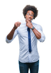 Afro american man holding visit card over isolated background serious face thinking about question, very confused idea