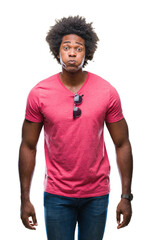 Afro american man over isolated background puffing cheeks with funny face. Mouth inflated with air, crazy expression. - obrazy, fototapety, plakaty