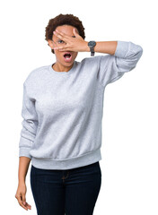 Fototapeta premium Young beautiful african american woman wearing glasses over isolated background peeking in shock covering face and eyes with hand, looking through fingers with embarrassed expression.