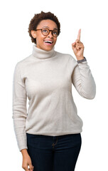 Young beautiful african american woman wearing glasses over isolated background pointing finger up with successful idea. Exited and happy. Number one.