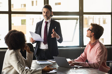 Middle aged man IT manager have work meeting with colleagues