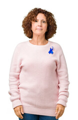 Middle ager senior woman wearing changeable blue color ribbon awareness over isolated background...