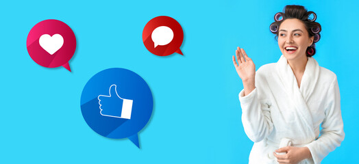 Young woman in bathrobe, with hair curlers and social network reactions on blue background