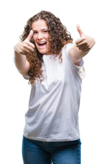 Beautiful brunette curly hair young girl wearing casual t-shirt over isolated background approving doing positive gesture with hand, thumbs up smiling and happy for success. Looking at the camera