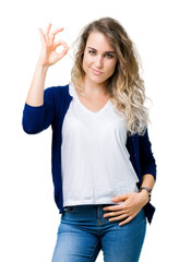 Beautiful young blonde woman over isolated background smiling positive doing ok sign with hand and fingers. Successful expression.