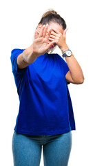 Young beautiful woman wearing casual blue t-shirt over isolated background covering eyes with hands and doing stop gesture with sad and fear expression. Embarrassed and negative concept.