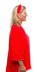 Middle age blonde woman over isolated background looking to side, relax profile pose with natural face with confident smile.