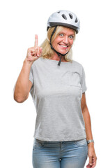 Middle age caucasian cyclist woman wearing safety helmet over isolated background pointing finger up with successful idea. Exited and happy. Number one.