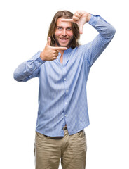 Fototapeta premium Young handsome man with long hair over isolated background smiling making frame with hands and fingers with happy face. Creativity and photography concept.