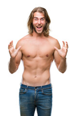 Fototapeta premium Young handsome shirtless man with long hair showing sexy body over isolated background celebrating crazy and amazed for success with arms raised and open eyes screaming excited. Winner concept