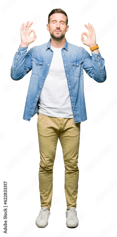 Wall mural Handsome man with blue eyes and beard wearing denim jacket relax and smiling with eyes closed doing meditation gesture with fingers. Yoga concept.