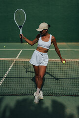 beautiful girl athlete plays tennis on the tennis court on a sunny summer day