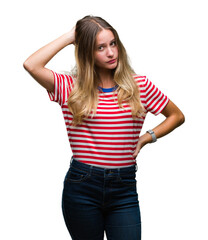 Fototapeta premium Young beautiful blonde woman over isolated background confuse and wonder about question. Uncertain with doubt, thinking with hand on head. Pensive concept.