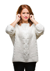 Young beautiful woman over isolated background wearing winter sweater covering ears with fingers with annoyed expression for the noise of loud music. Deaf concept.