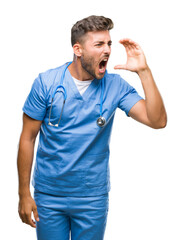 Young handsome doctor surgeon man over isolated background shouting and screaming loud to side with hand on mouth. Communication concept.