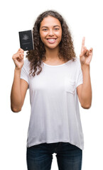 Young hispanic woman holding passport of Australia surprised with an idea or question pointing finger with happy face, number one