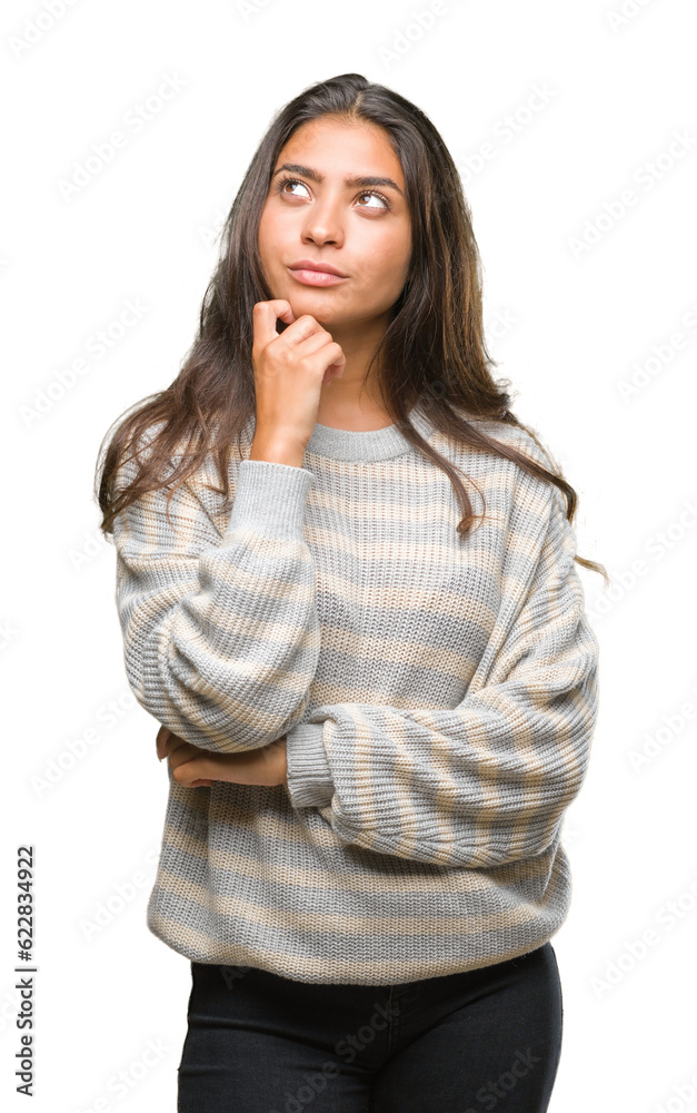 Poster Young beautiful arab woman wearing winter sweater over isolated background with hand on chin thinking about question, pensive expression. Smiling with thoughtful face. Doubt concept.