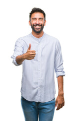 Fototapeta premium Adult hispanic man over isolated background doing happy thumbs up gesture with hand. Approving expression looking at the camera with showing success.