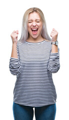 Young blonde woman over isolated background excited for success with arms raised celebrating victory smiling. Winner concept.