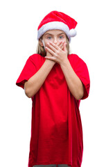 Young beautiful girl wearing christmas hat over isolated background shocked covering mouth with hands for mistake. Secret concept.