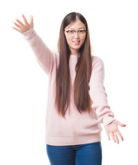 Young Chinese woman over isolated background wearing glasses looking at the camera smiling with open arms for hug. Cheerful expression embracing happiness.