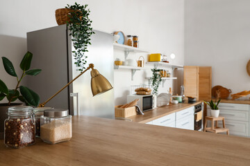 Interior of light kitchen with stylish fridge, counters and shelves