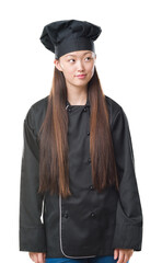 Young Chinese woman over isolated background wearing chef uniform smiling looking side and staring away thinking.