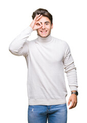 Young handsome man wearing turtleneck sweater over isolated background doing ok gesture with hand smiling, eye looking through fingers with happy face.