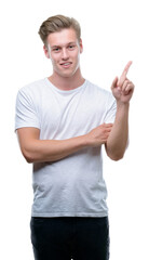 Naklejka premium Young handsome blond man very happy pointing with hand and finger to the side