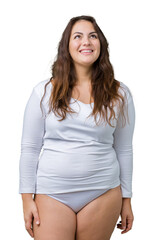 Fototapeta premium Beautiful plus size young overwight woman wearing white underwear over isolated background smiling looking side and staring away thinking.