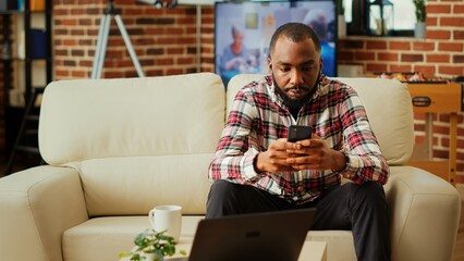 Annoyed african american man impatiently texting always late friend over supposed meeting hour....