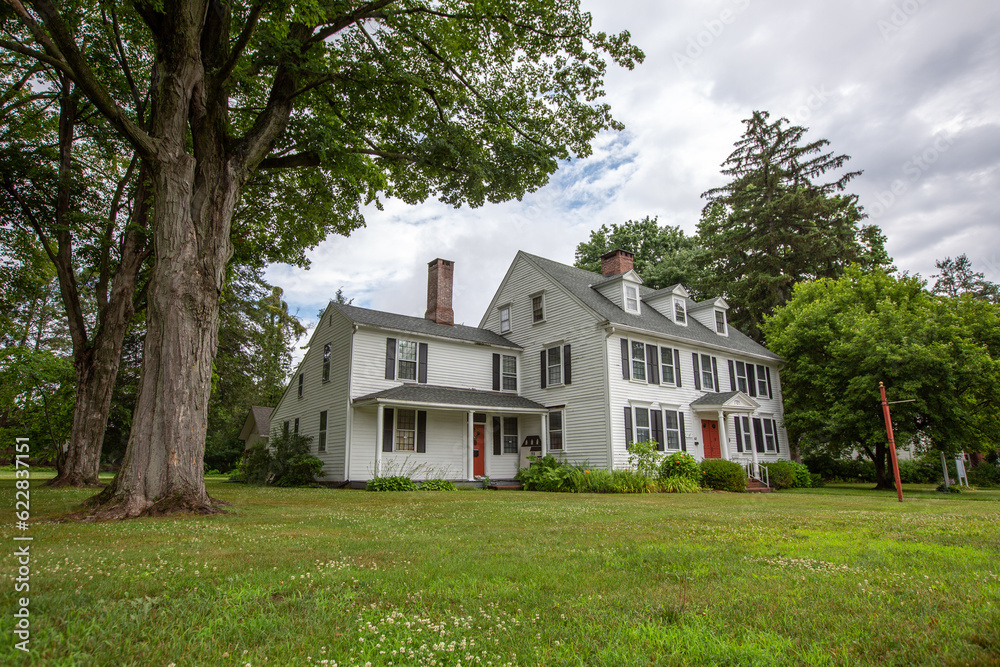 Wall mural Large white New England style historical colonial home with bump out and green lawn in Cheshire Connecticut