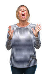 Middle age senior hispanic woman over isolated background crazy and mad shouting and yelling with aggressive expression and arms raised. Frustration concept.