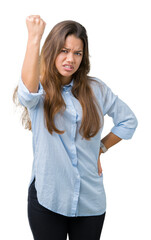 Young beautiful brunette business woman over isolated background angry and mad raising fist frustrated and furious while shouting with anger. Rage and aggressive concept.