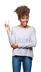 Beautiful young african american woman over isolated background smiling with happy face winking at the camera doing victory sign. Number two.