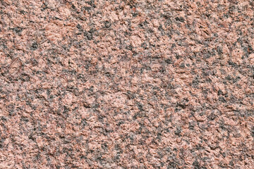 Granite stone surface. Red and black texture of a natural crystalline rock as a background