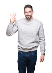 Fototapeta premium Young handsome man wearing sweatshirt over isolated background showing and pointing up with fingers number three while smiling confident and happy.