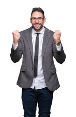 Young handsome business man over isolated background celebrating surprised and amazed for success with arms raised and open eyes. Winner concept.