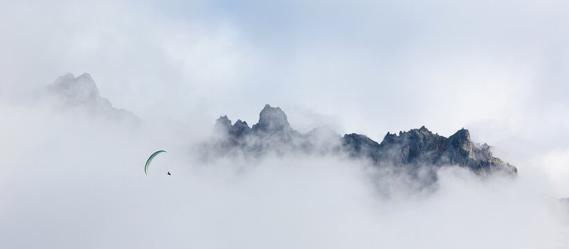 Person parachuting in cloudy sky