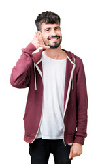 Young handsome man over isolated background smiling doing phone gesture with hand and fingers like talking on the telephone. Communicating concepts.