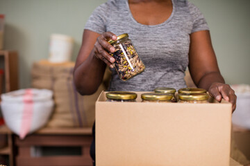 Woman arranging jars in brown box